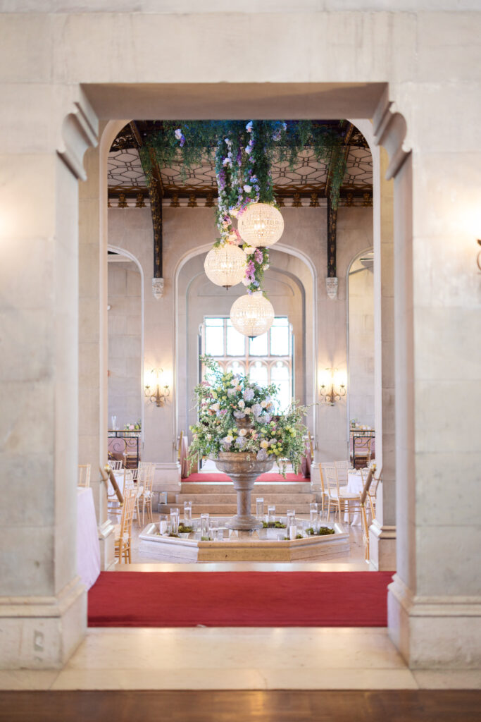 Indoor ceremony at Hempstead House featuring arched windows and floral decor.