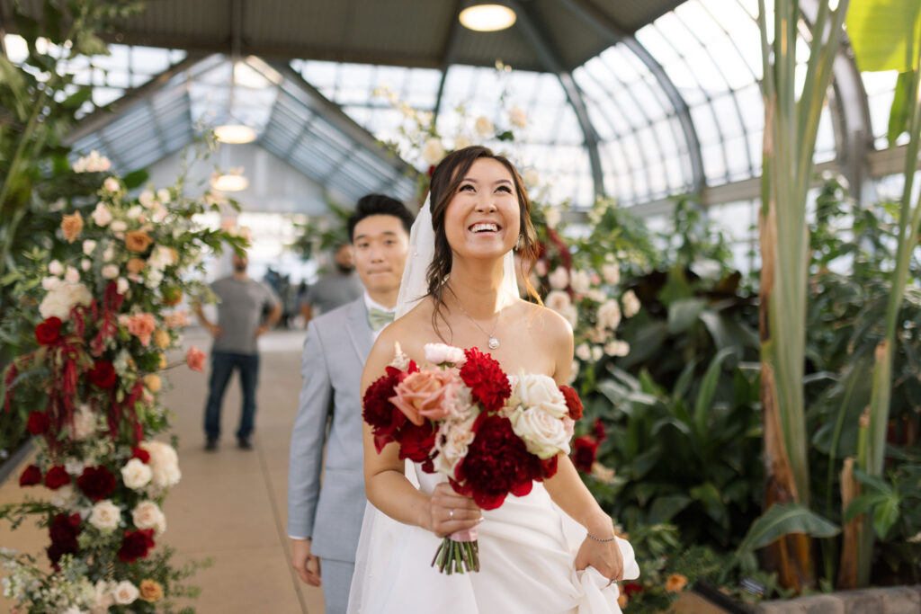 A stunning fall wedding at Garfield Park Conservatory in Chicago. The vibrant autumn foliage serves as a breathtaking backdrop for a couple’s ceremony in the Horticulture Hall, with floor-to-ceiling windows letting in the perfect natural light. Captured by Violet Carter Photography.